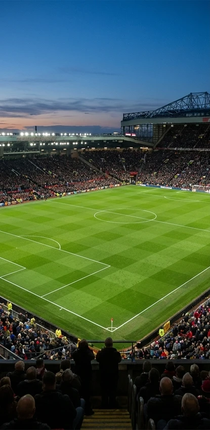 Illustrative football ground with a green pitch under evening floodlights